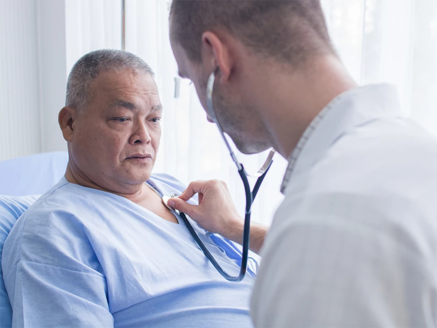 Doctor performing DOT health exam for CDL in Mid West using stethoscope on patient