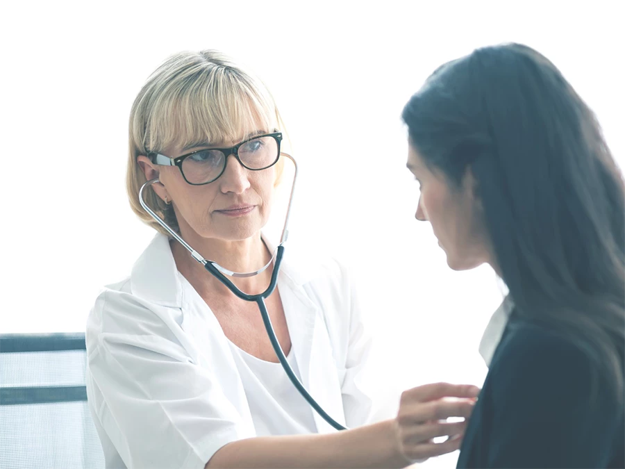 Doctor using stethoscope for DOT medical exam in Gulfton during patient check-up