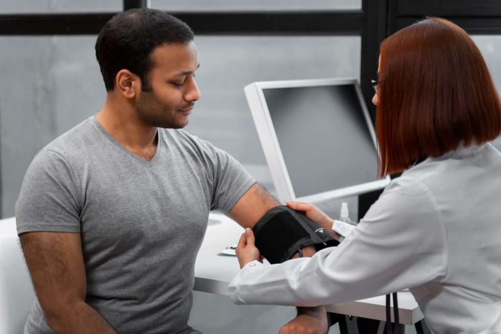 A doctor performing an affordable DOT physical in Houston, measuring blood pressure with a monitor in a clinic.