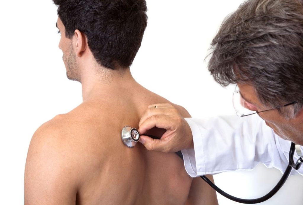 Healthcare provider performs back exam with stethoscope during Best Price DOT Physical Houston medical checkup.