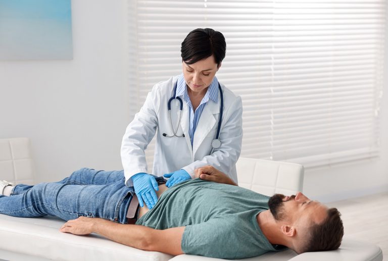 FMCSA Medical Examiner Houston performs an abdominal exam required for commercial driver certification.