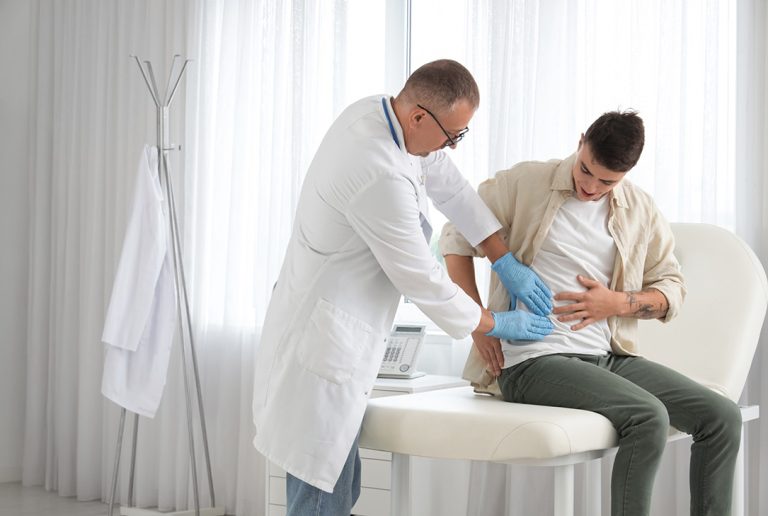 Urgent DOT Physical Houston: male doctor performs an essential abdomen exam on a seated patient.