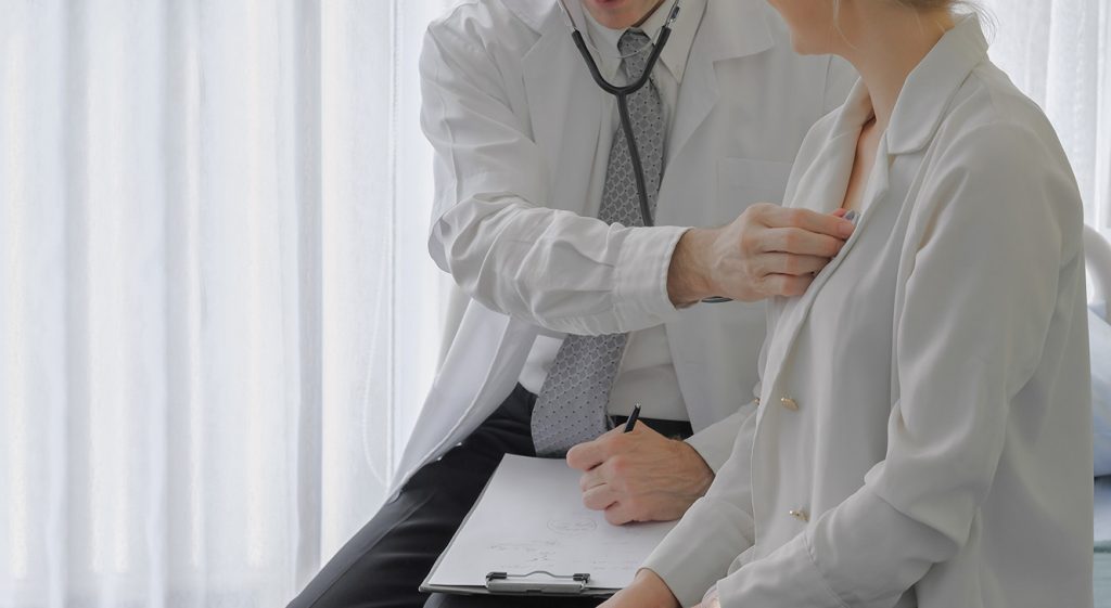 Urgent DOT Physical Houston provider conducts a thorough heart and lung examination on a female patient.