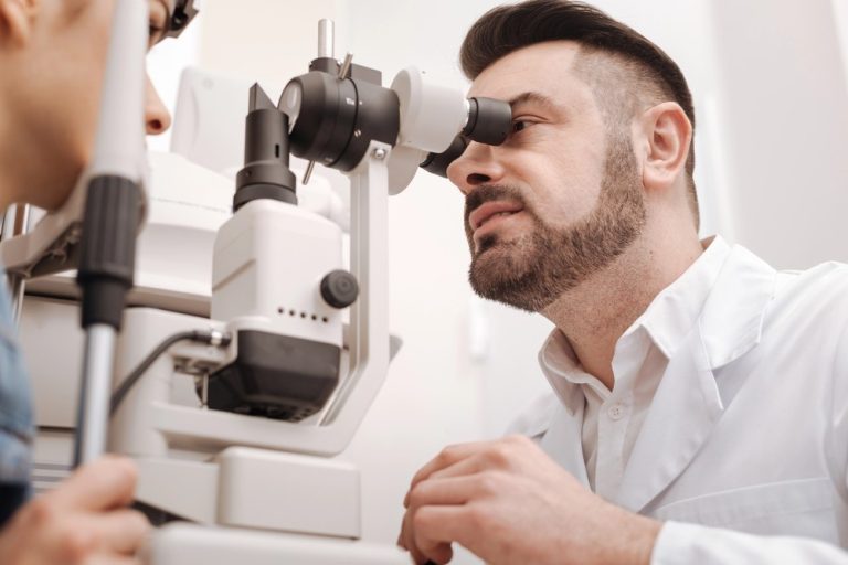 Eye doctor conducting slit lamp inspection—Urgent DOT Physical Houston vision screening required for CDL drivers.