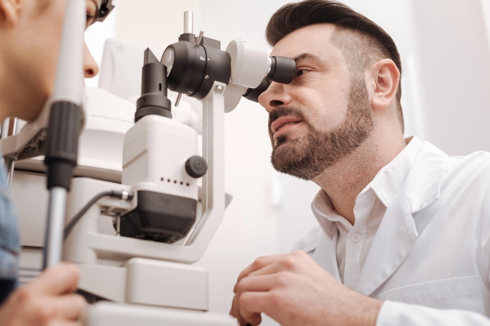 Eye doctor conducting slit lamp inspection—Urgent DOT Physical Houston vision screening required for CDL drivers.