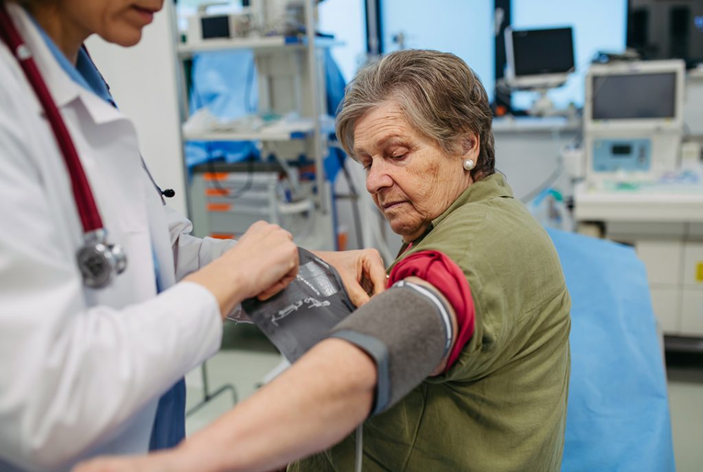 Doctor performing a required physical exam on an older patient for a DOT certification at a clinic in Houston.