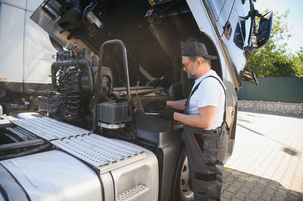 Mechanic inspects truck engine for safety compliance ahead of DOT Physical Houston TX and road readiness