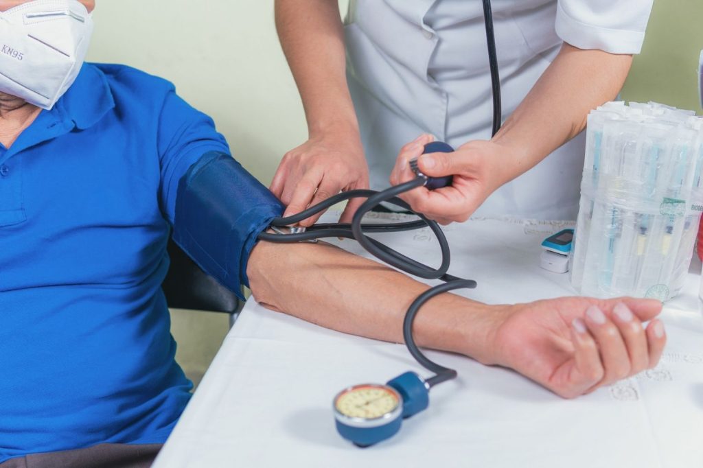 Nurse checking blood pressure for a DOT physical for CDL drivers Houston to meet federal driving requirements.