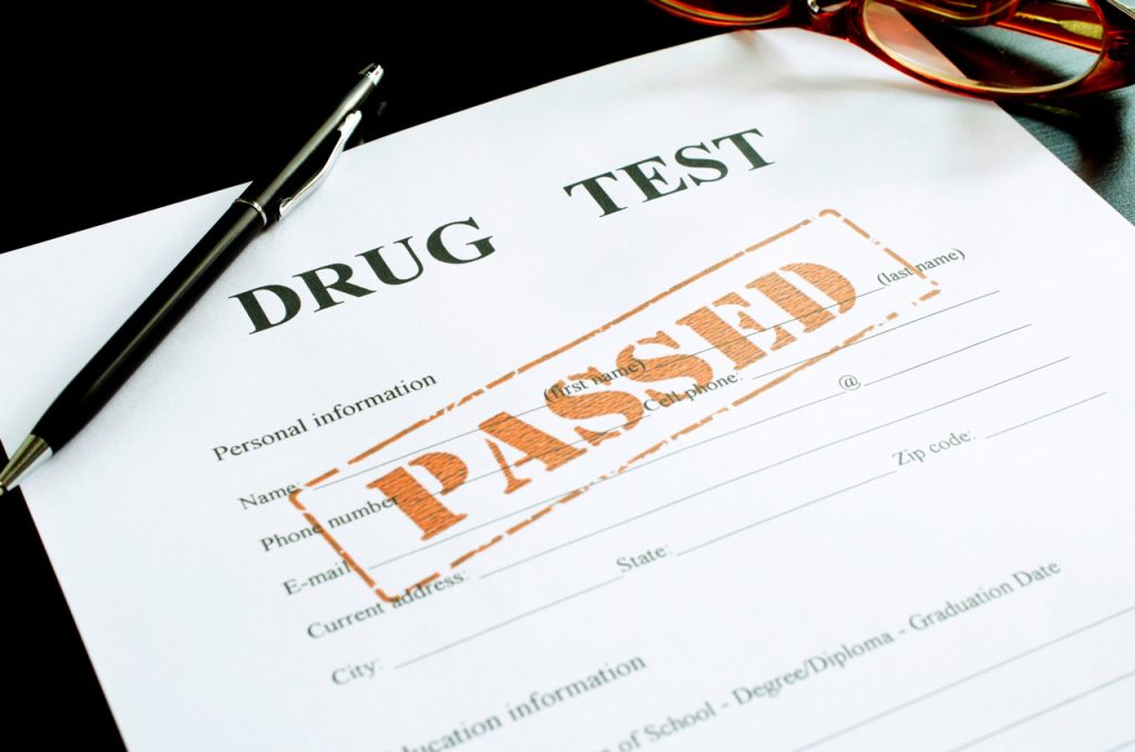 Official DOT drug test Houston results form with a large orange passed stamp on a personal information document.