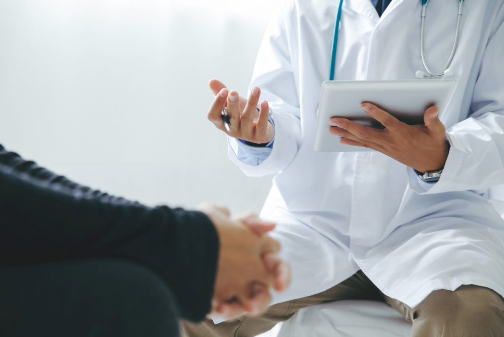 Certified examiner discussing certification requirements for a DOT physical open Saturday Houston with a truck driver.