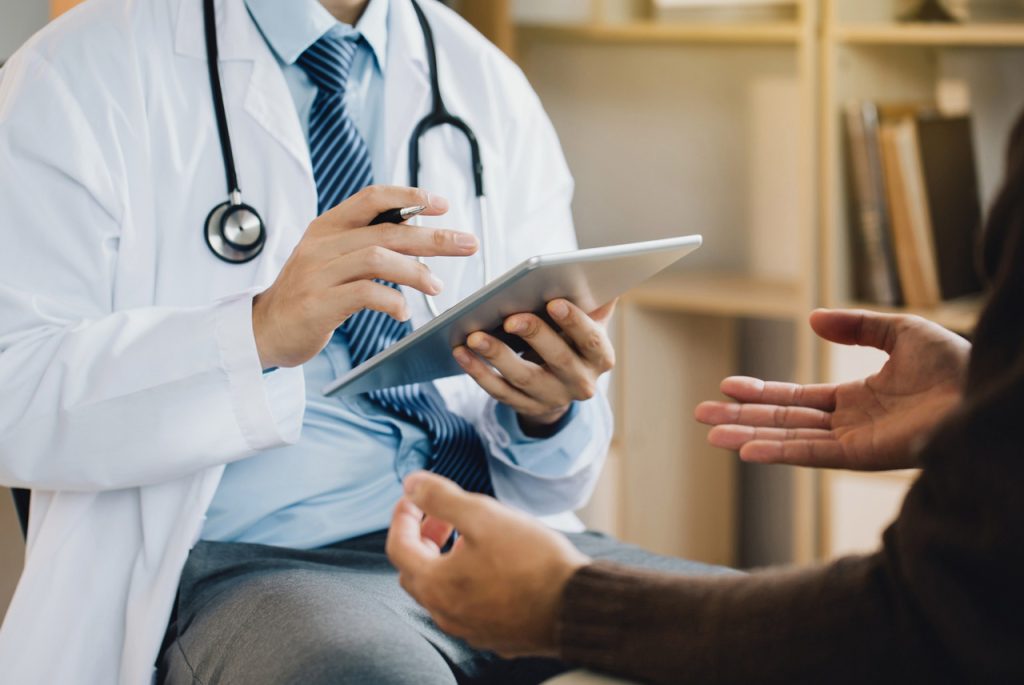 A medical examiner reviews digital health records for a DOT physical open Saturday Houston at a professional clinic.