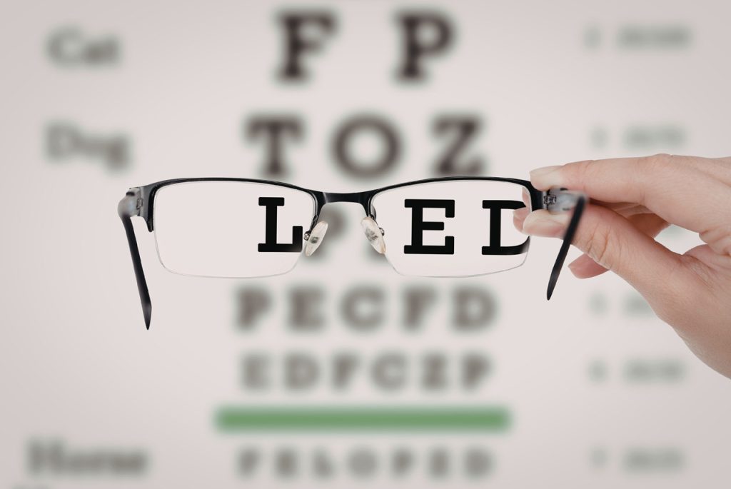 Snellen eye chart viewed through glasses for a CDL medical exam Houston, ensuring drivers meet vision requirements.
