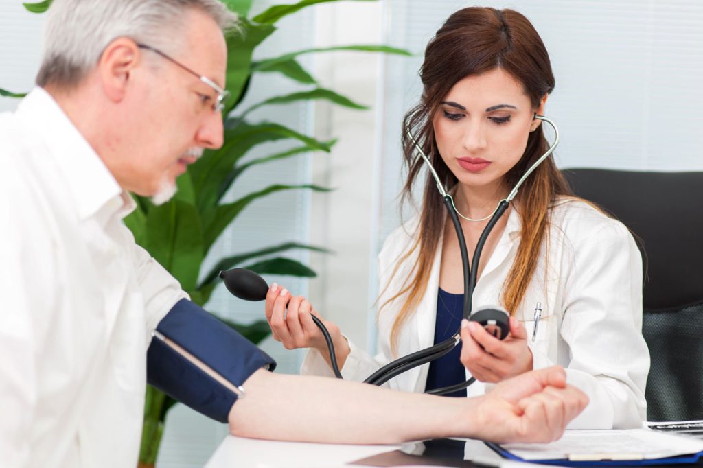 Medical professional conducting a blood pressure test for a CDL physical Houston exam to ensure driver health compliance.