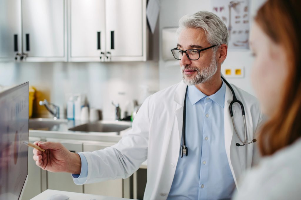 A Houston doctor reviews digital results for a DOT drug test Houston with a patient in a professional medical office.