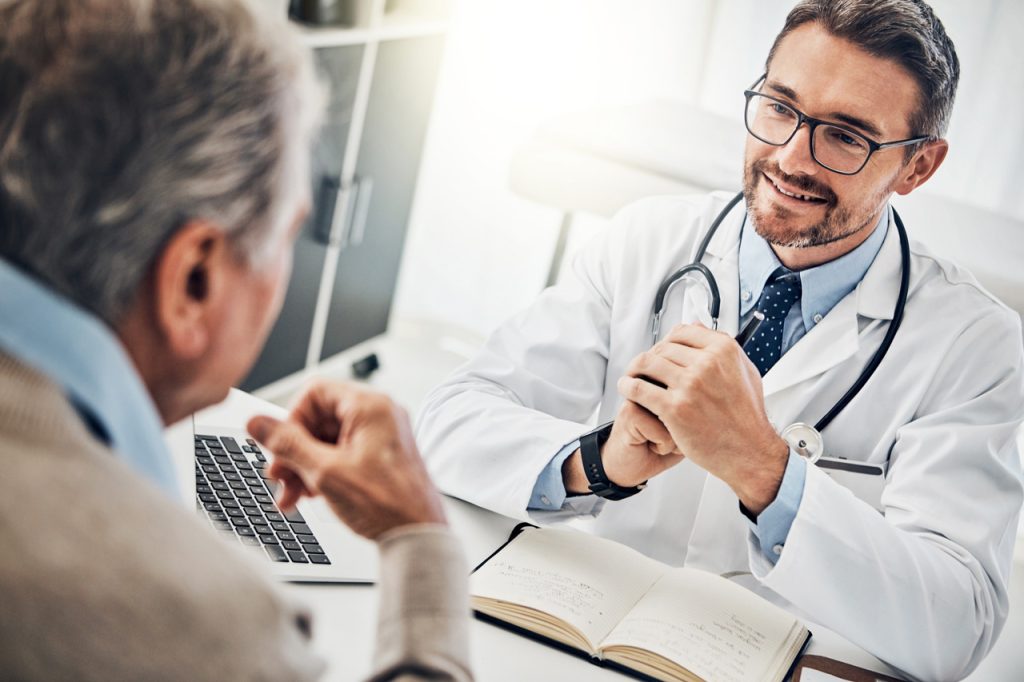 A friendly doctor consults with a patient for a dot physical open saturday houston at a modern medical clinic desk.