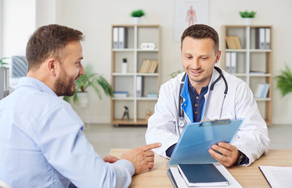 Male FMCSA medical examiner Houston discusses health history and DOT certification requirements with a CDL driver.