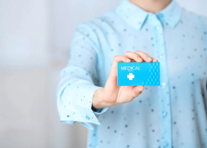 A person in a blue shirt holds a medical card issued by a top DOT certified medical examiner Houston clinic.
