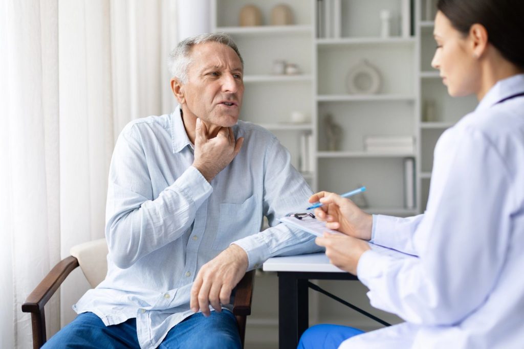 Commercial driver explaining health symptoms to a physician at a professional DOT physical Houston TX clinic.