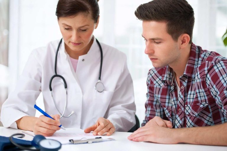 Certified medical examiner reviewing the official health history paperwork for a driver DOT physical Houston Tx.