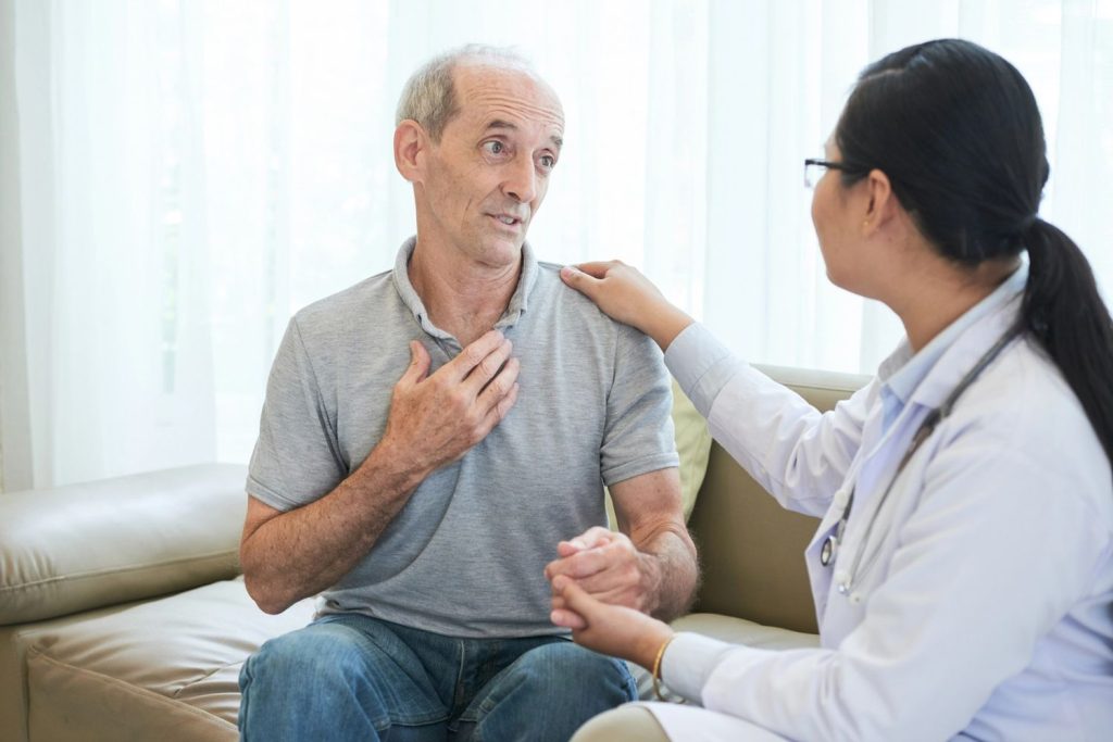 Senior driver discussing medical history with a doctor during a comprehensive DOT physical Houston TX exam.